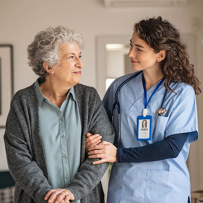 Altenpflegerin mit Patientin, Arm in Arm